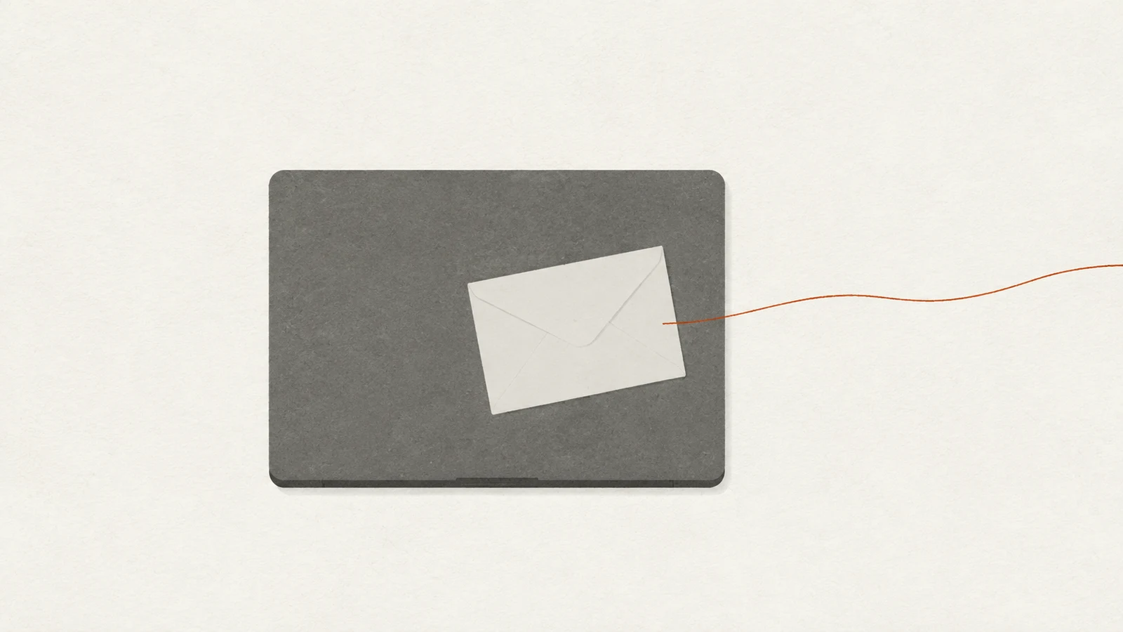 A desk seen from above holding a closed laptop with an envelope resting on it, and a faint line running off the edge of the frame.